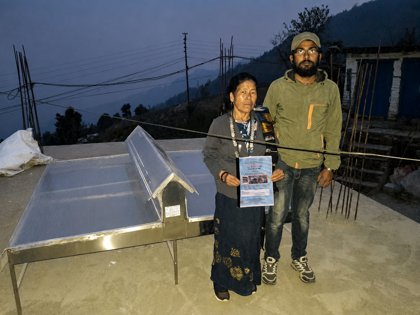 Anup Aryal beside a Solar Conduction Dryer during deployment in Modi Rural Municipality
